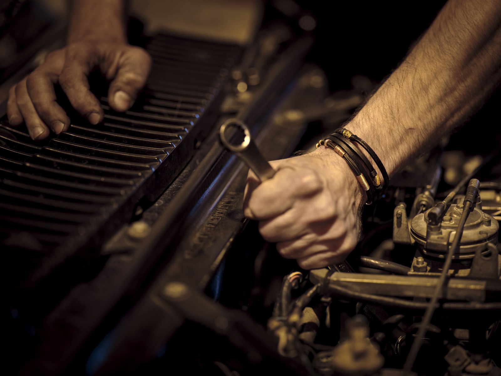 Atölyede bir aracın motor bölmesinde çalışan teknisyen